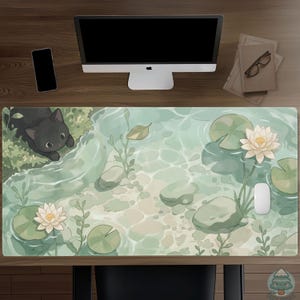 May include: A rectangular desk mat featuring a light green pond scene with a black cat peering into the water. The illustration includes white water lilies, green lily pads, smooth stones, and aquatic plants. A white computer mouse sits on the mat.