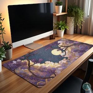 May include: A rectangular desk mat featuring a night sky design with a full moon, clouds, and purple flowering trees. The mat is on a wooden desk with a computer monitor and plants in the background.