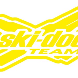 Puede incluir: Logotipo amarillo y blanco del equipo Ski-Doo. El logotipo tiene forma de X con las palabras "ski-doo" en una fuente estilizada y "TEAM" debajo. El dise&ntilde;o es una representaci&oacute;n gr&aacute;fica audaz.