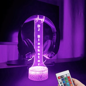 May include: A purple LED light with a clear acrylic stand that holds headphones. The stand has the text "DJ Blackstar" on it. The light comes with a remote control to change the color.