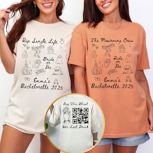 May include: Two t-shirts, one cream and one orange, with black graphic designs. The cream shirt says "Rip Single Life" and "Emma's Bachelorette 2025." The orange shirt says "The Mourning Crew" and "Emma's Bachelorette 2025." A third shirt is visible with a QR code.