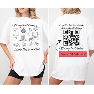 May include: White t-shirt with a black and white illustration of a cowboy boot, horseshoe, and other western themed icons. The text "It's my Last Rodeo" is printed on the shirt. The back of the shirt has a QR code and the text "Buy the bride a drink and make it strong".