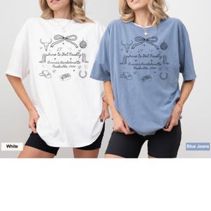 May include: Two women wearing oversized t-shirts with a black and white graphic design. The text on the shirts reads "Time to Get  Naughty" with the words "Emma's Bachelorette Nashville, 2025" underneath. The woman on the left is wearing a white t-shirt and the woman on the right is wearing a blue t-shirt.