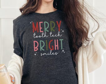 May include: A dark grey t-shirt with the text "Merry tooth tech bright smiles" in colorful letters.