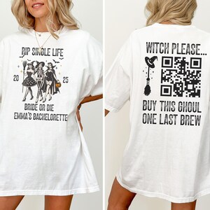 May include: White t-shirt with a Halloween-themed design. The front features text "RIP SINGLE LIFE" and "BRIDE OR DIE EMMA'S BACHELORETTE" with illustrations of witches. The back says "WITCH PLEASE..." and "BUY THIS GHOUL ONE LAST BREW" with a QR code.