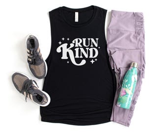 May include: A black muscle tank top with the words "RUN KIND" in white script and star accents. The image also includes gray athletic shoes, lavender leggings, and a teal water bottle with a floral design.