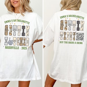 May include: White t-shirt with the text "EMMA'S BACHELORETTE GETTIN HITCHED NASHVILLE - 2025" on the front. The back of the shirt says "EMMA'S BACHELORETTE GETTIN TIPSY BUY THE BRIDE A DRINK" with a QR code.