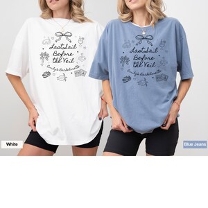 May include: Two women wearing oversized t-shirts with a nautical theme. The white t-shirt has black text that says "Last Sail Before the Veil" and the blue t-shirt has white text that says "Last Sail Before the Veil". Both shirts have a cute graphic design with a sailboat, palm tree, and a turtle.