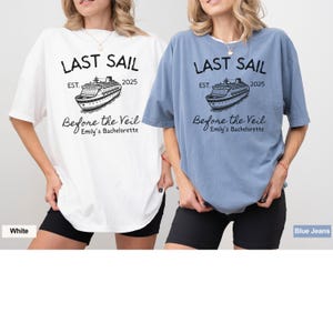 May include: Two women wearing oversized t-shirts with a cruise ship graphic and the text "Last Sail Est. 2025 Before the Veil Emily's Bachelorette". The t-shirt on the left is white and the t-shirt on the right is blue.