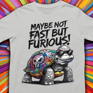 May include: A gray t-shirt with a colorful turtle wearing sunglasses and the text "Maybe not fast but furious!"