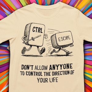 May include: A beige t-shirt with a graphic of two computer keys, one labeled "CTRL" and the other "ESCAPE", running away from each other. The text below the graphic reads "Don't allow anyone to control the direction of your life."