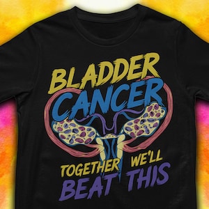 May include: Black t-shirt with a graphic design of a bladder with the text "Bladder Cancer Together We'll Beat This" in yellow, blue, and purple.