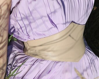 May include: A lavender strapless dress with a pleated bodice and a wide beige leather belt.
