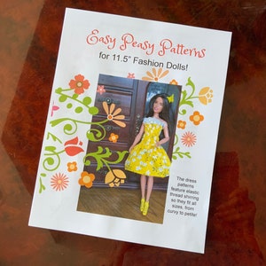 May include: A white paper with the text "Easy Peasy Patterns for 11.5" Fashion Dolls!" and a picture of a doll wearing a yellow dress with white flowers. The text below the picture says "The dress patterns feature elastic thread shirring so they fit all sizes, from curvy to petite!"