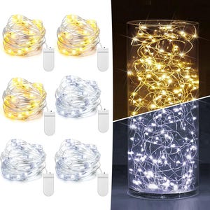 May include: A set of six battery-operated LED string lights with thin silver wire. The lights are shown in both warm yellow and cool white color temperatures, coiled into bundles with white battery packs and displayed inside a glass cylinder.