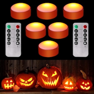 May include: Six round orange LED puck lights with glowing warm yellow tops, accompanied by two silver remote controls featuring buttons for timer settings, light modes, and brightness adjustment, alongside five carved jack-o'-lantern pumpkins.