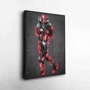 K&ouml;nnte beinhalten: Gerahmtes Kunstwerk mit einer stilisierten Darstellung einer Figur in einem schwarz-roten Anzug vor einem dunkelgrauen Hintergrund. Das Kunstwerk verwendet einen Spritzeffekt, um ein dynamisches und energiegeladenes Gef&uuml;hl zu erzeugen. Die Figur h&auml;lt eine Waffe.
