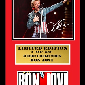Könnte beinhalten: Ein Schwarzweißbild eines Mannes, der auf der Bühne singt. Das Bild ist in Rot und Gold gerahmt. Der Text "LIMITED EDITION 1 OF 50 MUSIC COLLECTION BON JOVI" befindet sich auf dem goldenen Rahmen. Der Text "BON JOVI" befindet sich auf einem rot-weißen Logo unterhalb des Rahmens.