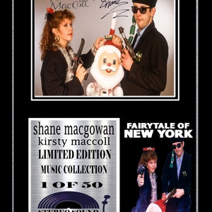 Puede incluir: Una colección de música de edición limitada con Shane MacGowan y Kirsty MacColl. La portada del álbum presenta una foto en blanco y negro de los dos músicos sosteniendo pistolas de juguete y un muñeco de Papá Noel. El texto "Fairytale of New York" está impreso en blanco sobre un fondo negro.
