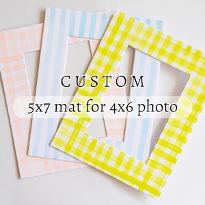 May include: Three custom picture frames with different patterns. The frames are 5x7 inches and have a 4x6 inch opening. The patterns are pink and white gingham, blue and white stripes, and yellow and white gingham.