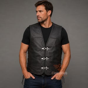 May include: A black leather waistcoat featuring a braided trim along the edges, a V-neckline, and three silver-toned metal hook-and-eye closures down the front. The waistcoat includes side lacing details and two horizontal slit pockets on the lower front.