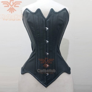 May include: A black leather corset with a sweetheart neckline and a busk closure. The corset has a smooth, shiny finish and is accented with silver-toned metal hardware.