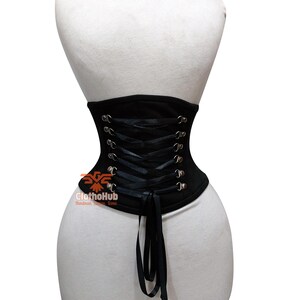 May include: Black corset with silver eyelets and black ribbon lacing. The corset is displayed on a white mannequin. The ClotHub logo is visible on the lower left side of the corset.