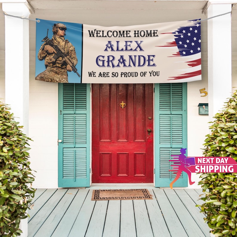 Op de afbeelding: Een welkom thuis-banner met een verweerd Amerikaans vlagontwerp. De banner luidt "Welcome Home Alex Grande We Are So Proud Of You". Een soldaat in militair uniform is afgebeeld aan de linkerkant van de banner.