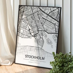 May include: Black and white map print of Stockholm, Sweden. The map shows the city's streets and waterways. The text "STOCKHOLM - SWEDEN 59.334545°N | 18.063240°E" is printed at the bottom of the map.