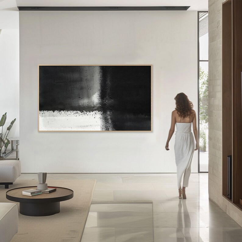 May include: A black and white abstract painting with a horizontal line dividing the canvas. The top half is black with a white vertical line, and the bottom half is white with black brushstrokes.