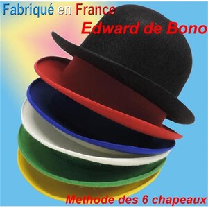 Peut inclure: Six chapeaux en feutre de différentes couleurs, empilés les uns sur les autres. Les chapeaux sont noir, rouge, bleu, blanc, vert et jaune. Le chapeau du haut porte le texte "Edward de Bono". Le chapeau du bas porte le texte "Methode des 6 chapeaux".
