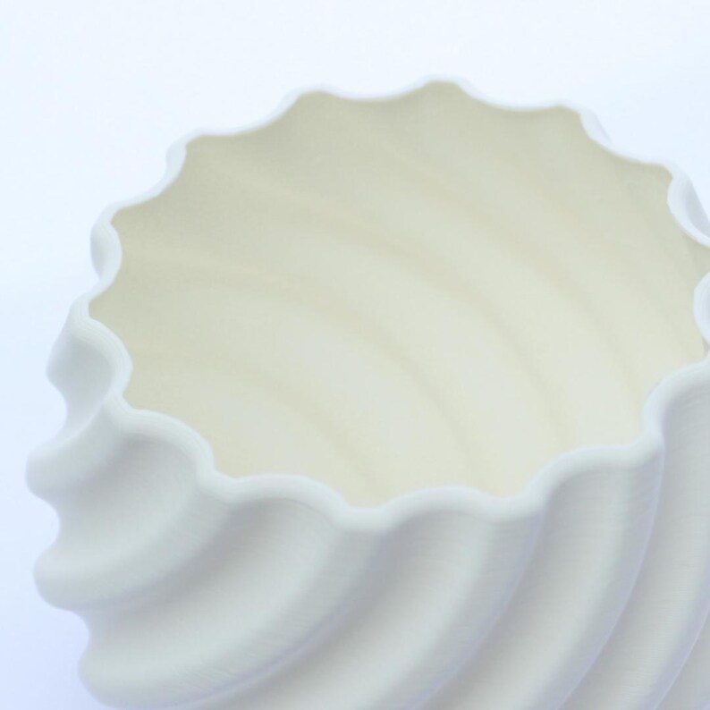 Close up image of a white 3D printed plant pot, photographed on a white background.