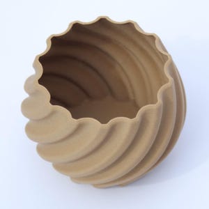 Beige-coloured 3D printed plant pot, photographed on a white background.