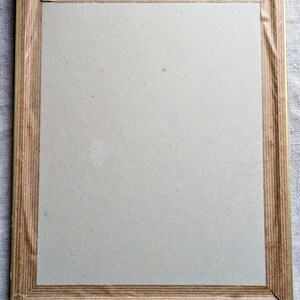 K&ouml;nnte beinhalten: Ein einfacher Holzbildrahmen mit goldener Verzierung. Der Rahmen ist leer und bereit, ein Foto oder ein Kunstwerk zu pr&auml;sentieren.