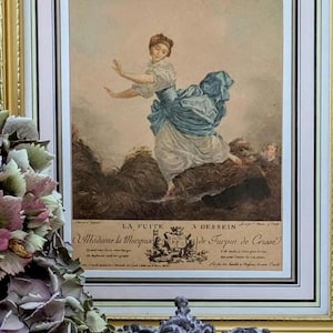 Könnte beinhalten: Ein gerahmter Druck einer Frau in einem blauen Kleid, die vor einem Mann davonläuft. Der Druck ist betitelt "La Fuite a Dessein a Madame la Marquise de Turpin de Crusse".