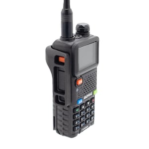 May include: A black handheld two-way radio with an antenna, a small screen, and a keypad with numbers and directional arrows. The radio has a black and orange button on the side and the text "BAOFENG" on the front.