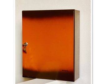 May include: A brown metal box with a keyhole and the word "Stromberg" printed on the front.
