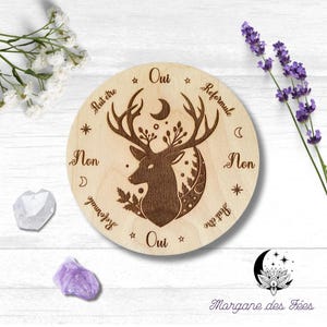 Peut inclure: Plateau de divination circulaire en bois avec une silhouette de cerf et les mots "Oui", "Non", "Peut etre", "Reformule", et "Peut etre" autour du bord.