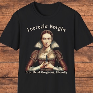 May include: A black short-sleeved t-shirt featuring a graphic of Lucrezia Borgia in a red dress with a high collar and pearl necklaces. She holds a small dagger. The text reads Lucrezia Borgia above and Drop Dead Gorgeous. Literally below.