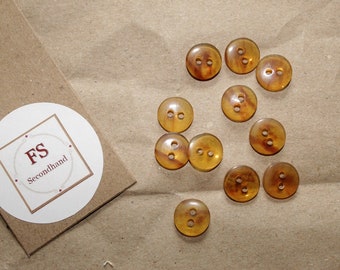 11 transparent/brown two-hole buttons, craft and sewing supplies