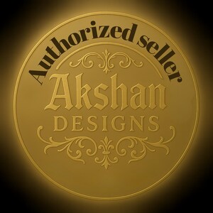 Puede incluir: Un emblema circular dorado con las palabras "Authorized seller" en texto negro en el borde superior. El nombre "Akshan DESIGNS" est&aacute; en letras doradas ornamentadas en el centro, con adornos decorativos.