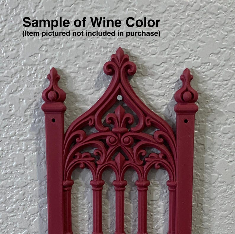 Puede incluir: Un elemento arquitect&oacute;nico decorativo de color burdeos con detalles ornamentados. El dise&ntilde;o presenta una forma de arco g&oacute;tico con barras verticales y pin&aacute;culos decorativos. El texto "Sample of Wine Color" est&aacute; en la parte superior.