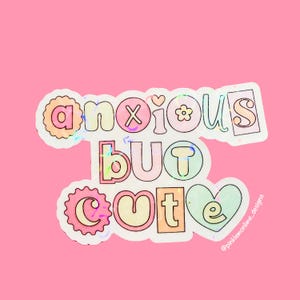 May include: A sticker with a holographic finish featuring the text "anxious but cute" in a colourful, playful font. The sticker has a pink, blue, and green colour scheme.