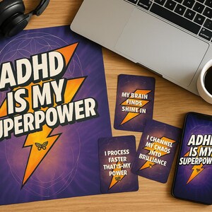 May include: A collection of items with the text "ADHD IS MY SUPERPOWER" on a large print, a phone screen, and playing cards. The cards have phrases like "My brain finds shine in" and "I process faster". A laptop and coffee cup are also present.