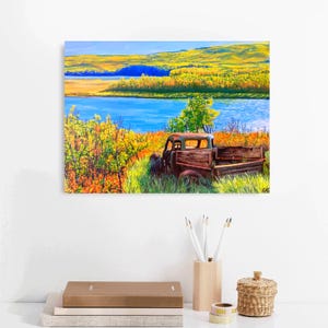 May include: A colorful painting of a rural landscape featuring a blue lake, yellow and green trees, and an old, weathered truck. The truck is brown and appears to be made of wood and metal, and is parked in tall grass.