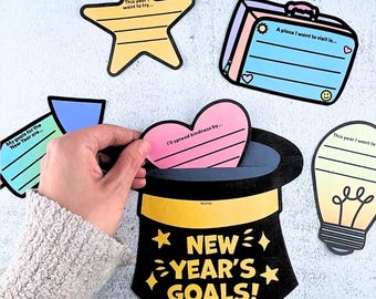 Puede incluir: Una colección de coloridas tarjetas de metas de Año Nuevo. Las tarjetas tienen forma de estrella, maleta, corazón, bombilla y sombrero de copa con el texto "NEW YEAR'S GOALS!". La tarjeta en forma de corazón dice "I'll spread kindness by..."