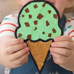 Puede incluir: Un recorte de papel con forma de cono de helado con un contorno negro. La bola est&aacute; hecha de trozos de papel verde claro con virutas de papel marr&oacute;n, y el cono est&aacute; construido con trozos de papel color canela dispuestos en mosaico.