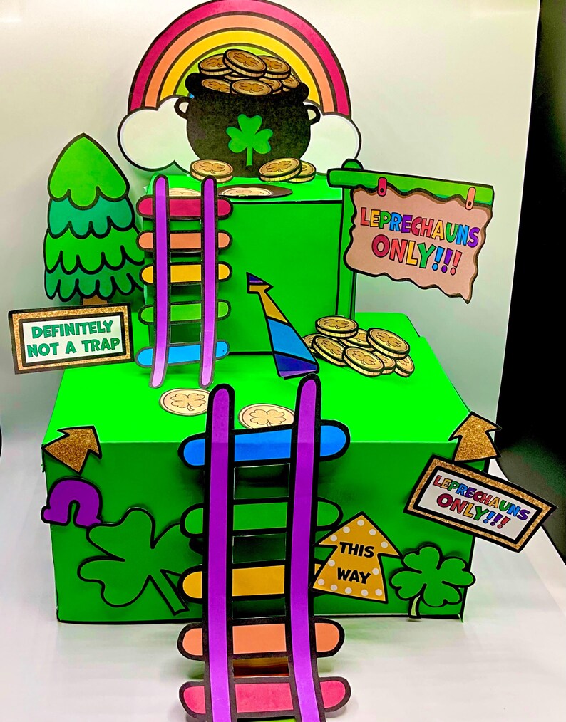 Op de afbeelding: Een groene doos met een regenboog, een pot met goud en een bord met de tekst "Leprechauns Only!!". Er zijn twee ladders die naar de doos leiden, een met paarse en oranje treden en de andere met blauwe en gele treden. De doos heeft een bord met de tekst "Definitely Not a Trap" en een ander bord met de tekst "This Way".