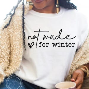 May include: White t-shirt with black text that reads "not made for winter" with a small heart symbol.