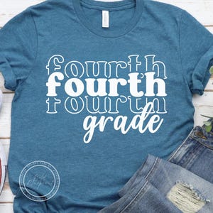 May include: Teal blue t-shirt with the words "fourth grade" in white, stacked vertically. The word "fourth" is repeated three times, with the middle word in a bold font. The shirt is made of a soft material.